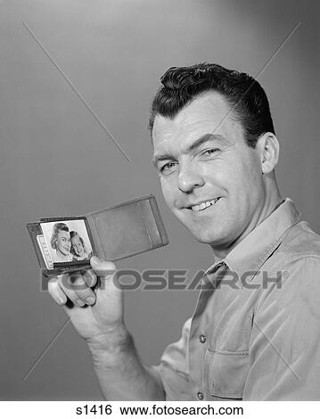 1950S Smiling Man Holding Up Wallet With Picture Of Wife And Daughter View Large Photo Image Stock Photograph - 1950S Smiling Man Holding Up Wallet With Picture Of Wife And Daughter. Fotosearch