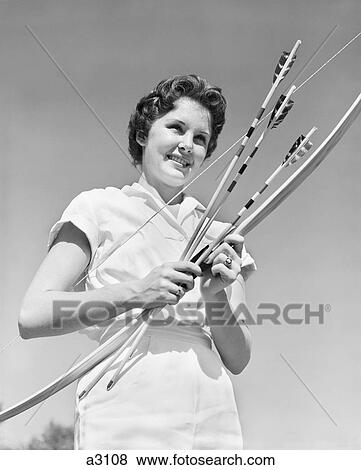 Stock Photo - 1950S Smiling Teenage Woman Holding Bow And Arrows Wearing White Blouse Sports Recreation . Fotosearch