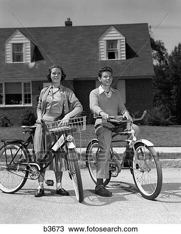 1950S Smiling Teens On Suburban Street Boy Sitting On Bike Girl Standing Beside Bike With Basket View Large Photo Image Stock Image - 1950S Smiling Teens On Suburban Street Boy Sitting On Bike Girl Standing Beside Bike With Basket. Fotosearch