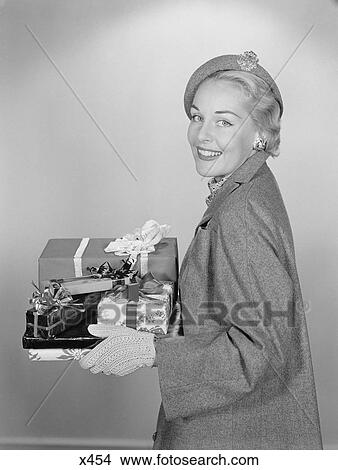 1950S Smiling Woman Holding Wrapped Christmas Presents Looking At Camera View Large Photo Image Picture - 1950S Smiling Woman Holding Wrapped Christmas Presents Looking At Camera. Fotosearch