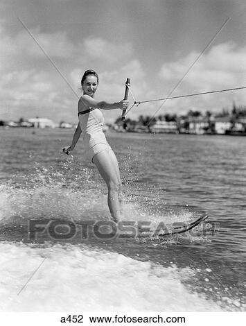 1950S Smiling Woman In Bathing Suit Water Skiing Waving One Hand View Large Photo Image Stock Image - 1950S Smiling Woman In Bathing Suit Water Skiing Waving One Hand. Fotosearch