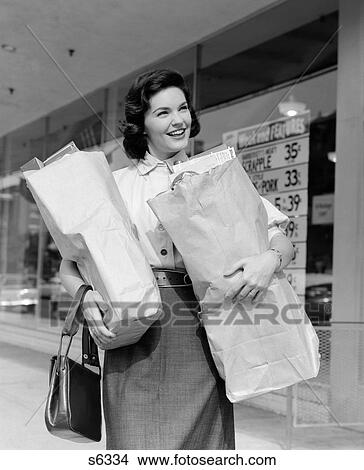 1950S Smiling Woman Outside Of Grocery Store Holding Brown Paper Bags With Pocketbook Hanging On Wrist View Large Photo Image Picture - 1950S Smiling Woman Outside Of Grocery Store Holding Brown Paper Bags With Pocketbook Hanging On Wrist. Fotosearch
