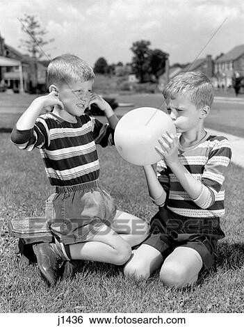 1950S Two Young Boys One Blowing Up Balloon One With Fingers In Ears Afraid Of Explosion View Large Photo Image Stock Photograph - 1950S Two Young Boys One Blowing Up Balloon One With Fingers In Ears Afraid Of Explosion. Fotosearch