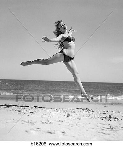 1950S Woman In Bikini Running And Jumping On The Beach Smiling View Large Photo Image Stock Photograph - 1950S Woman In Bikini Running And Jumping On The Beach Smiling. Fotosearch