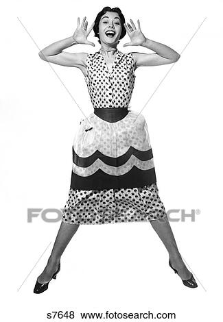1950S Woman In Dress & Apron Jumping In Air With Legs Apart & Palms Spread To Either Side Of Face With Mouth Open Looking At Camera View Large Photo Image Stock Photo - 1950S Woman In Dress & Apron Jumping In Air With Legs Apart & Palms Spread To Either Side Of Face With Mouth Open Looking At Camera. Fotosearch