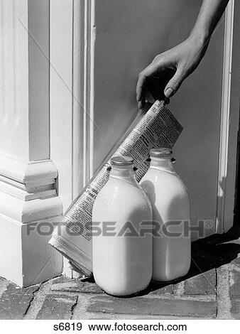 1950S Woman'S Hand Reaching Down For Newspaper Propped Against 2 Bottles Of Milk At Doorstep View Large Photo Image Stock Photo - 1950S Woman'S Hand Reaching Down For Newspaper Propped Against 2 Bottles Of Milk At Doorstep. Fotosearch