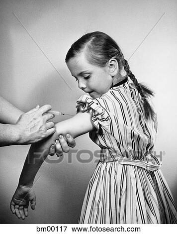 1950S Young Girl Getting Vaccination Shot In Her Arm Stock Photo