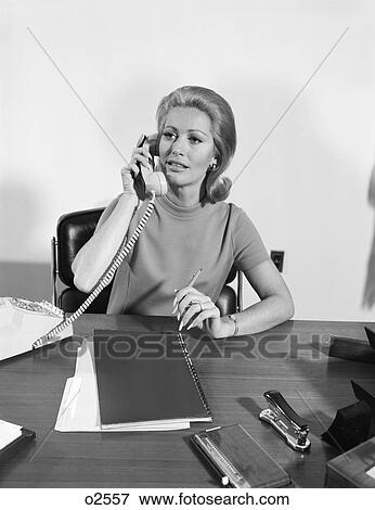 1960S 1970S Blond Businesswoman Talking On Telephone Sitting At Desk View Large Photo Image Stock Photo - 1960S 1970S Blond Businesswoman Talking On Telephone Sitting At Desk. Fotosearch