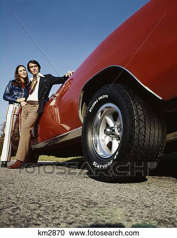 Stock Image - 1960S 1970S Couple With Red Sports Car. Fotosearch