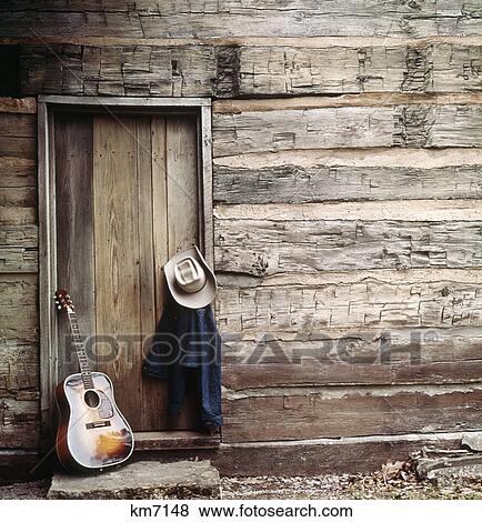 1960S 1970S Guitar, Hat And Jacket Hanging By Weathered Log Cabin Door View Large Photo Image Stock Photo - 1960S 1970S Guitar, Hat And Jacket Hanging By Weathered Log Cabin Door. Fotosearch