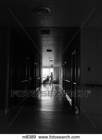 1960S 1970S Nurse Pushing Elderly Female Patient Down Dark Hospital Hallway In Wheelchair View Large Photo Image Stock Photo - 1960S 1970S Nurse Pushing Elderly Female Patient Down Dark Hospital Hallway In Wheelchair. Fotosearch