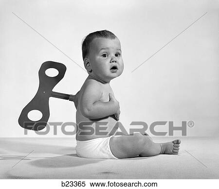 Stock Photography - 1960S 1970S Seated Baby In Diaper With Windup Key In His Back. Fotosearch
