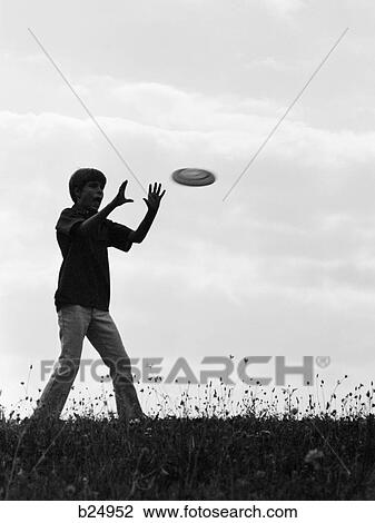 1960S 1970S Silhouette Of Boy Catching Frisbee In Field View Large Photo Image Stock Image - 1960S 1970S Silhouette Of Boy Catching Frisbee In Field. Fotosearch