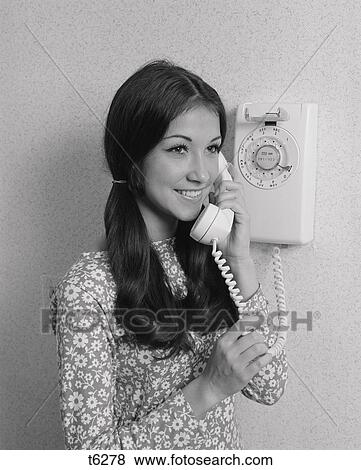 1960S 1970S Smiling Teenage Girl Talking On Rotary Wall Telephone View Large Photo Image Stock Photo - 1960S 1970S Smiling Teenage Girl Talking On Rotary Wall Telephone. Fotosearch
