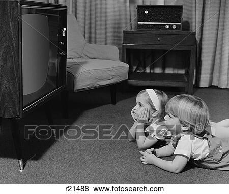 1960S 1970S Two Toddlers Boy Girl Lying On Floor Watching Television View Large Photo Image Stock Photo - 1960S 1970S Two Toddlers Boy Girl Lying On Floor Watching Television. Fotosearch