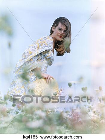 1960S 1970S Young Woman Field Of Flowers Print Dress Straw Hat View Large Photo Image Stock Photography - 1960S 1970S Young Woman Field Of Flowers Print Dress Straw Hat . Fotosearch