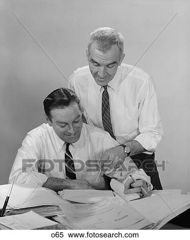 1960S 2 Businessmen In Shirt Sleeves Looking Over Paperwork View Large Photo Image Stock Photography - 1960S 2 Businessmen In Shirt Sleeves Looking Over Paperwork . Fotosearch