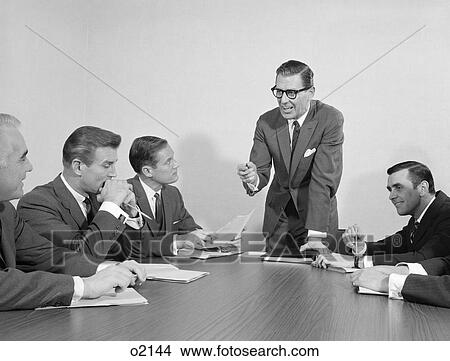 1960S 5 Executive Businessmen Meeting At Conference Table One Man Standing View Large Photo Image Picture - 1960S 5 Executive Businessmen Meeting At Conference Table One Man Standing. Fotosearch