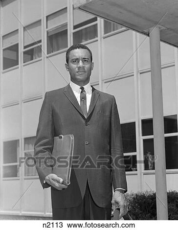 Stock Image - 1960S African-American Businessman Holding Briefcase Outdoors. Fotosearch