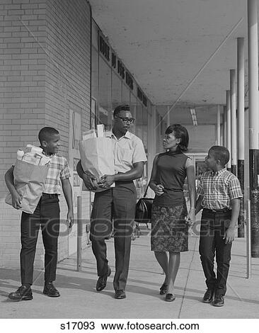 Stock Image - 1960S African American Family Carrying Grocery Bags. Fotosearch