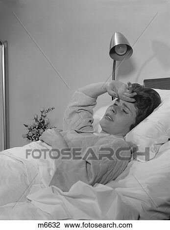 1960S Ailing Woman Patient Lying In Hospital Bed Hand Pressed To Forehead View Large Photo Image Stock Image - 1960S Ailing Woman Patient Lying In Hospital Bed Hand Pressed To Forehead. Fotosearch