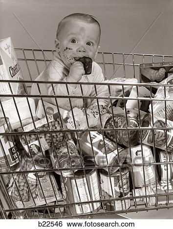 1960S Baby Sitting In Supermarket Cart Full Of Cans Eating Candy Bar With A Messy Face View Large Photo Image Stock Photograph - 1960S Baby Sitting In Supermarket Cart Full Of Cans Eating Candy Bar With A Messy Face. Fotosearch