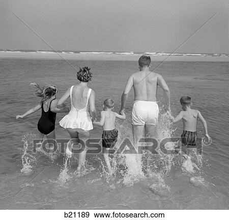 1960S Back View Of Family Of 5 Holding Hands Running Into Ocean View Large Photo Image Stock Photo - 1960S Back View Of Family Of 5 Holding Hands Running Into Ocean. Fotosearch