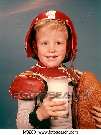 1960S Blond Boy Smiling Wearing Red Helmet Football Shoulder Pads Holding Glass Milk And Football Looking At Camera View Large Photo Image Stock Photo - 1960S Blond Boy Smiling Wearing Red Helmet Football Shoulder Pads Holding Glass Milk And Football Looking At Camera. Fotosearch