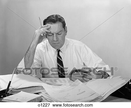 1960S Businessman Desk Full Papers Hand To Forehead Serious Expression View Large Photo Image Stock Photo - 1960S Businessman Desk Full Papers Hand To Forehead Serious Expression. Fotosearch