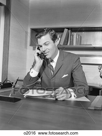 Stock Photograph - 1960S Businessman Executive At Desk Talking On Telephone. Fotosearch