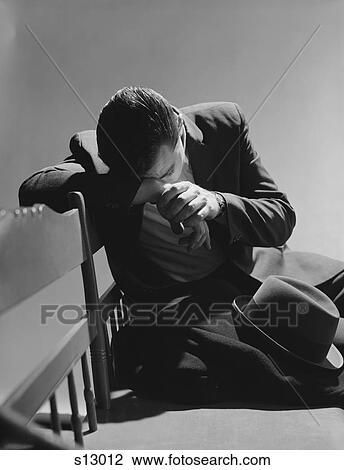 Stock Image - 1960S Businessman Sitting On Bench Head Down On Arms Slumped Over Sad Depressed. Fotosearch