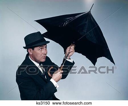 1960S Businessman Wearing Hat Opening Umbrella To Protect From Rain View Large Photo Image Stock Image - 1960S Businessman Wearing Hat Opening Umbrella To Protect From Rain . Fotosearch