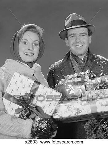 Stock Image - 1960S Couple Man And Woman Holding Wrapped Christmas Presents And Packages. Fotosearch