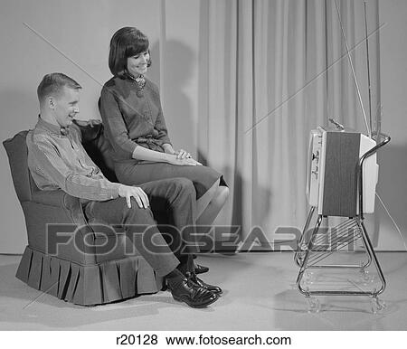Stock Photo - 1960S Couple Man Woman Sitting Chair Watching Portable Television. Fotosearch