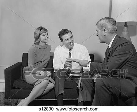 1960S Couple Sitting On Couch Talking To Salesman View Large Photo Image Stock Image - 1960S Couple Sitting On Couch Talking To Salesman. Fotosearch
