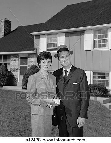 1960S Couple Smiling Man And Woman Standing Before Suburban House View Large Photo Image Stock Photo - 1960S Couple Smiling Man And Woman Standing Before Suburban House. Fotosearch