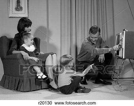 Stock Image - 1960S Family Mother Father Son Daughter Watching Television In Living Room Indoor. Fotosearch