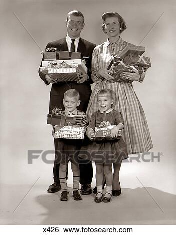 1960S Family Portrait Of Four Mother Father Boy Girl Carrying Christmas Gifts Wrapped Presents View Large Photo Image Stock Photograph - 1960S Family Portrait Of Four Mother Father Boy Girl Carrying Christmas Gifts Wrapped Presents. Fotosearch