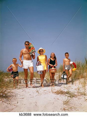 1960S Family Walking Together To The Beach Over Sand Dunes Carry Picnic And Beach Gear View Large Photo Image Stock Photo - 1960S Family Walking Together To The Beach Over Sand Dunes Carry Picnic And Beach Gear . Fotosearch
