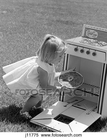 1960S Girl In Yard Squatting Down Taking Cake Out Of Play Oven View Large Photo Image Stock Photography - 1960S Girl In Yard Squatting Down Taking Cake Out Of Play Oven. Fotosearch