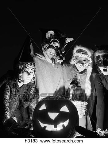1960S Group Of Four Children In Halloween Costumes Gathered Around Jack-O'-Lantern Indoor View Large Photo Image Stock Image - 1960S Group Of Four Children In Halloween Costumes Gathered Around Jack-O'-Lantern Indoor. Fotosearch