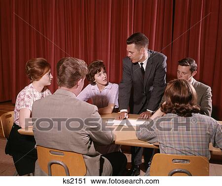 1960S Group Of Six Students Sitting At Around A Table Talking Three Boys Three Girls Teenage Indoor View Large Photo Image Stock Image - 1960S Group Of Six Students Sitting At Around A Table Talking Three Boys Three Girls Teenage Indoor . Fotosearch