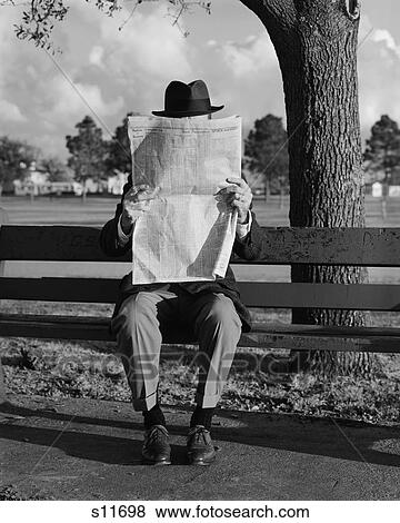 Stock Photo - 1960S Humor Portrait Man Wearing Hat Sitting On Park Bench Reading Newspaper . Fotosearch