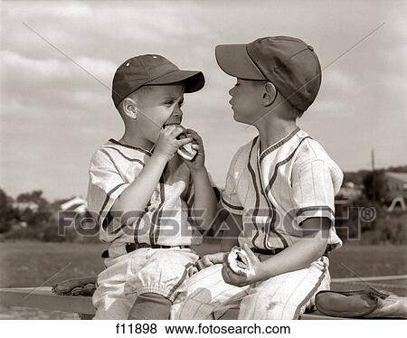 1960S Little League Baseball Boys In Caps And Uniforms Eating Hot Dogs View Large Photo Image Stock Photo - 1960S Little League Baseball Boys In Caps And Uniforms Eating Hot Dogs. Fotosearch