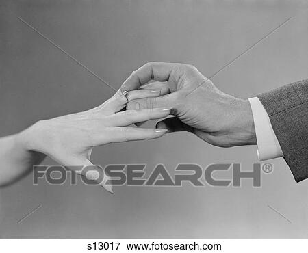 1960S Male Hand Slipping Engagement Ring Onto Female Hand View Large Photo Image Stock Photo - 1960S Male Hand Slipping Engagement Ring Onto Female Hand. Fotosearch