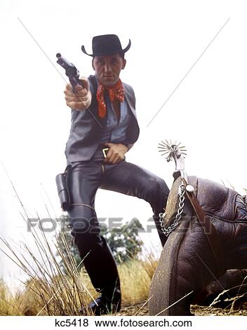 1960S Man Cowboy In Black Hat Shooting Gun Dead Man On Ground View Large Photo Image Stock Photo - 1960S Man Cowboy In Black Hat Shooting Gun Dead Man On Ground . Fotosearch