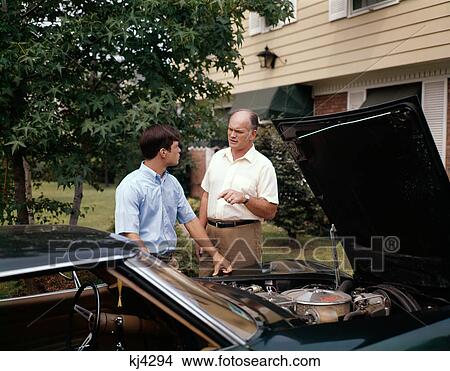 1960S Man Father And Teenage Son Talking About The Engine Of The Family Car View Large Photo Image Picture - 1960S Man Father And Teenage Son Talking About The Engine Of The Family Car. Fotosearch