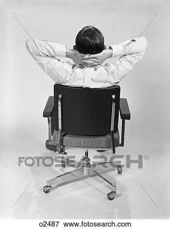 1960S Man From Behind Sitting In Office Executive Chair Hands Clasped Behind Neck View Large Photo Image Stock Photo - 1960S Man From Behind Sitting In Office Executive Chair Hands Clasped Behind Neck. Fotosearch