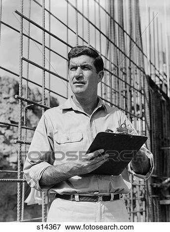 1960S Man On Construction Site Holding Clipboard View Large Photo Image Stock Photo - 1960S Man On Construction Site Holding Clipboard. Fotosearch