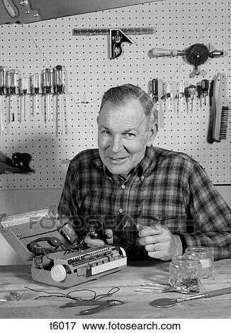 1960S Man Repairing Portable Radio In Home Workshop Smiling Looking At Camera Indoor View Large Photo Image Stock Photo - 1960S Man Repairing Portable Radio In Home Workshop Smiling Looking At Camera Indoor. Fotosearch